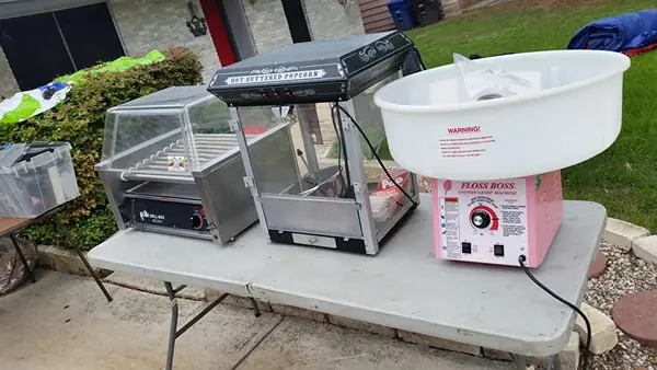 Hotdog, popcorn, and cotton candy machines set up on a table
